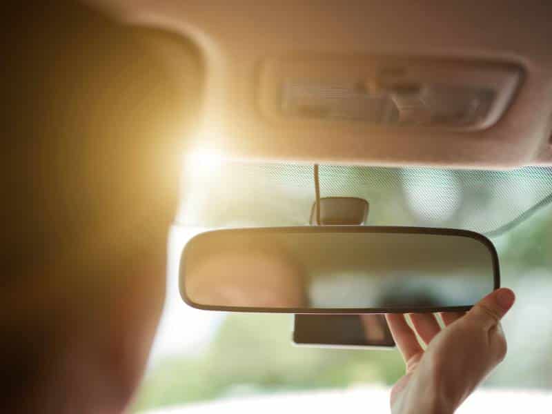 Candidato se preparando para exame de direção ajustando o espelho